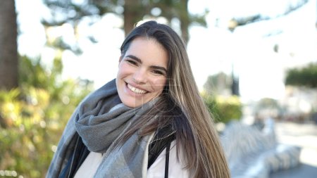 Téléchargez les photos : Jeune belle femme hispanique souriant confiant à la rue - en image libre de droit