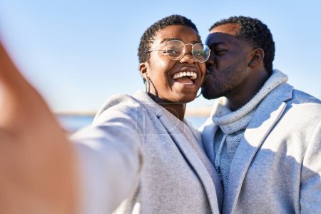 Photo for Man and woman couple standing together make selfie by the camera at seaside - Royalty Free Image