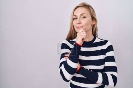 Photo for Young caucasian woman wearing casual navy sweater looking confident at the camera smiling with crossed arms and hand raised on chin. thinking positive. - Royalty Free Image