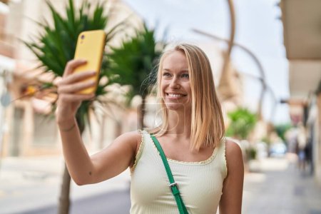 Photo for Young blonde woman smiling confident making selfie by the smartphone at street - Royalty Free Image