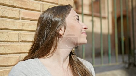 Téléchargez les photos : Young beautiful hispanic woman smiling confident looking to the sky at street - en image libre de droit