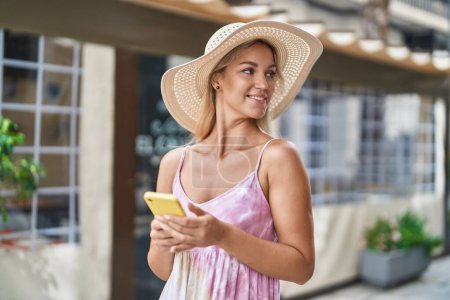 Téléchargez les photos : Jeune femme blonde touriste souriant confiant parler sur smartphone à la terrasse du café - en image libre de droit