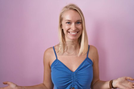 Photo for Young caucasian woman standing over pink background smiling cheerful with open arms as friendly welcome, positive and confident greetings - Royalty Free Image