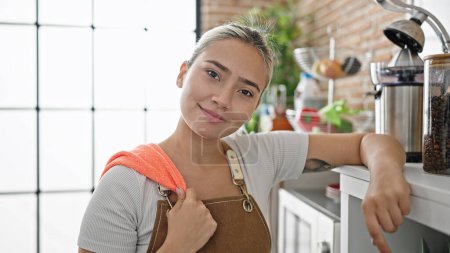 Photo for Young beautiful hispanic woman wearing apron smiling confident at dinning room - Royalty Free Image