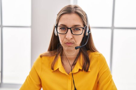 Photo for Young woman wearing call center agent headset thinking attitude and sober expression looking self confident - Royalty Free Image
