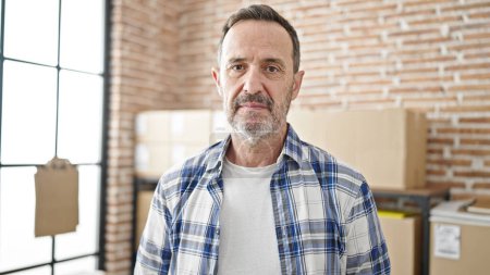 Photo for Middle age man ecommerce business worker standing with relaxed expression at office - Royalty Free Image