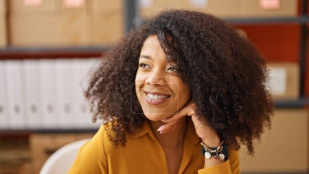Foto de Mujer afroamericana comercio electrónico trabajador de negocios sentado en la mesa sonriendo en la oficina - Imagen libre de derechos
