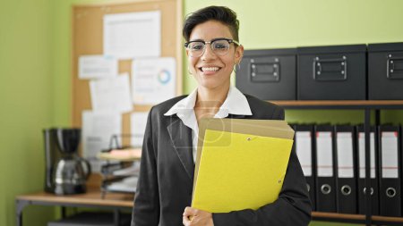 Photo for Young beautiful hispanic woman business worker smiling confident holding documents at office - Royalty Free Image