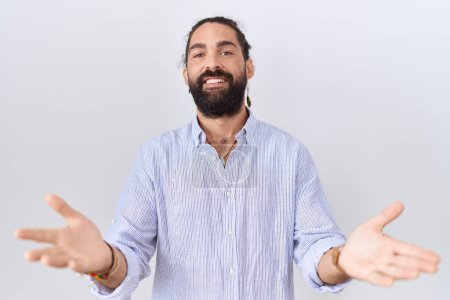 Téléchargez les photos : Homme hispanique avec barbe portant chemise décontractée souriant joyeuse offrant des mains donnant assistance et acceptation. - en image libre de droit