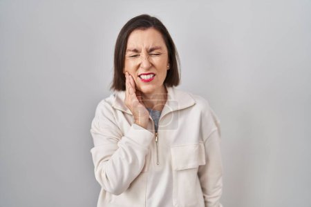 Téléchargez les photos : Femme hispanique du Moyen Âge debout sur fond isolé touchant la bouche avec la main avec une expression douloureuse à cause de maux de dents ou de maladies dentaires sur les dents. dentiste - en image libre de droit