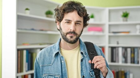 Téléchargez les photos : Jeune homme hispanique étudiant portant un sac à dos à l'université de la bibliothèque - en image libre de droit