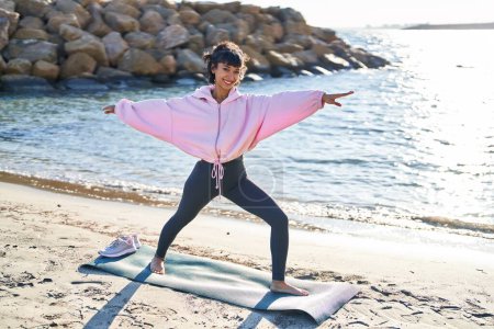 Téléchargez les photos : Jeune femme entraînement yoga exercice debout au bord de la mer - en image libre de droit