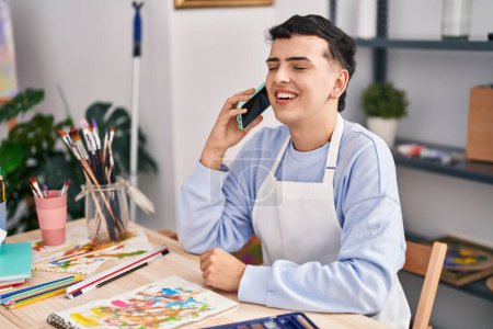 Photo for Young non binary man artist smiling confident talking on the smartphone at art studio - Royalty Free Image