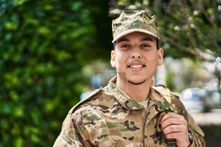 Foto de Joven soldado del ejército sonriendo confiado de pie en el parque - Imagen libre de derechos
