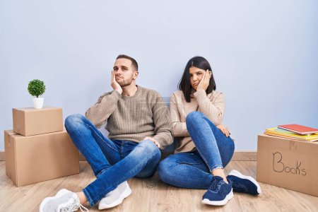 Photo for Young couple moving to a new home thinking looking tired and bored with depression problems with crossed arms. - Royalty Free Image
