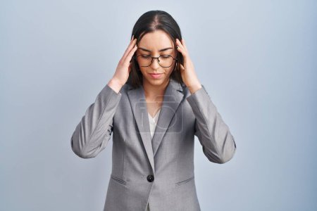 Photo for Hispanic business woman wearing glasses with hand on head for pain in head because stress. suffering migraine. - Royalty Free Image