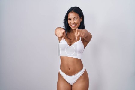Photo for Hispanic woman wearing lingerie pointing to you and the camera with fingers, smiling positive and cheerful - Royalty Free Image
