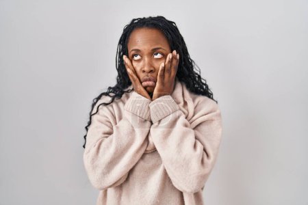 Téléchargez les photos : Femme africaine debout sur fond blanc mains fatiguées couvrant le visage, la dépression et la tristesse, bouleversé et irrité par le problème - en image libre de droit