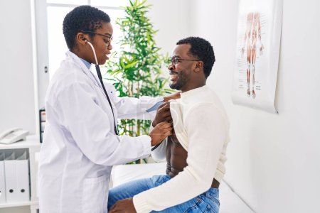 Man and woman doctor and patient having medical consultation auscultating chest at clinic