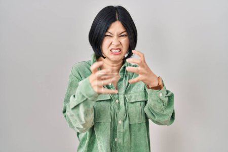 Téléchargez les photos : Jeune femme asiatique debout sur fond blanc criant frustré par la rage, les mains essayant d'étrangler, hurlant fou - en image libre de droit