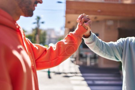 Foto de Dos parejas de hombres de pie con las manos juntas en la calle - Imagen libre de derechos