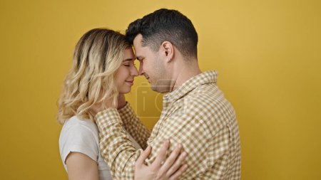 Foto de Hombre y mujer pareja abrazándose de pie sobre un fondo amarillo aislado - Imagen libre de derechos