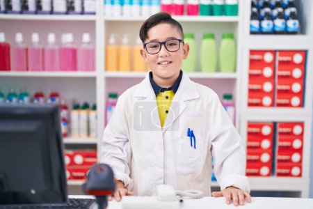 Téléchargez les photos : Jeune hispanique travaillant à la pharmacie avec un sourire joyeux et cool sur le visage. chanceux. - en image libre de droit