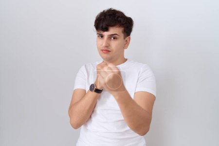 Photo for Young non binary man wearing casual white t shirt ready to fight with fist defense gesture, angry and upset face, afraid of problem - Royalty Free Image