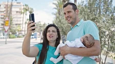 Téléchargez les photos : Famille de trois personnes prenant selfie ensemble dans la rue - en image libre de droit