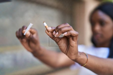 Photo for Young african american woman breaking cigarette at street - Royalty Free Image