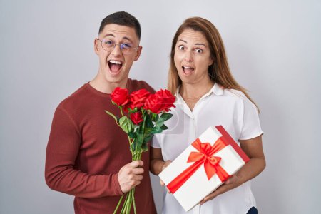 Photo for Mother and son holding mothers day gift celebrating crazy and amazed for success with open eyes screaming excited. - Royalty Free Image