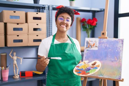 Photo for Young african american woman drawing on canvas at art studio smiling with a happy and cool smile on face. showing teeth. - Royalty Free Image