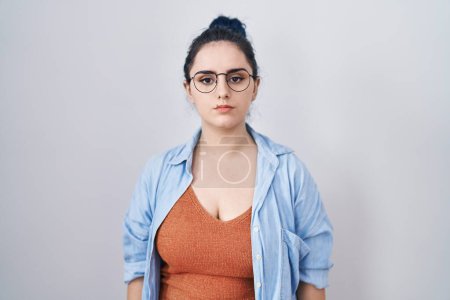 Photo for Young modern girl with blue hair standing over white background relaxed with serious expression on face. simple and natural looking at the camera. - Royalty Free Image
