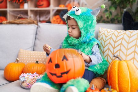 Photo for Adorable hispanic boy having halloween party holding sweets at home - Royalty Free Image