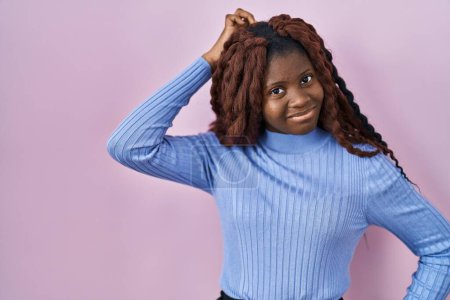 Téléchargez les photos : Femme africaine debout sur fond rose confondre et se poser des questions. incertain avec doute, pensant la main sur la tête. concept coûteux. - en image libre de droit
