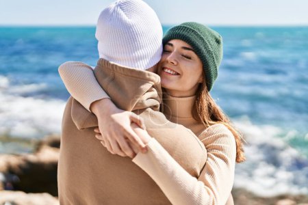 Photo for Mand and woman couple smiling confident hugging each other at seaside - Royalty Free Image