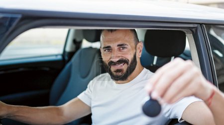 Téléchargez les photos : Young hispanic man smiling confident holding key of new car at street - en image libre de droit