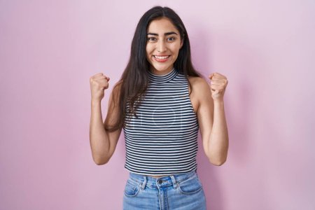 Photo for Young teenager girl wearing casual striped t shirt celebrating surprised and amazed for success with arms raised and open eyes. winner concept. - Royalty Free Image