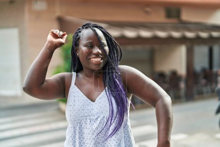 Téléchargez les photos : Femme afro-américaine souriante danse confiante sur la terrasse du café - en image libre de droit