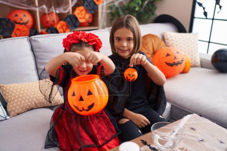 Photo for Adorable boy and girl having halloween party holding pumpkin basket at home - Royalty Free Image