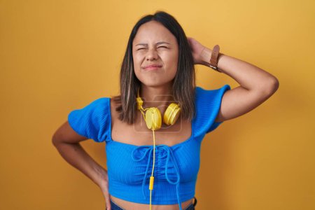 Photo for Hispanic young woman standing over yellow background suffering of neck ache injury, touching neck with hand, muscular pain - Royalty Free Image