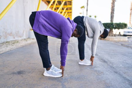 Photo for Man and woman couple wearing sportswear stretching at street - Royalty Free Image