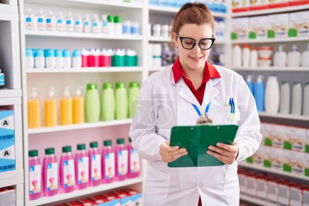 Photo for Young beautiful plus size woman pharmacist smiling confident reading document at pharmacy - Royalty Free Image