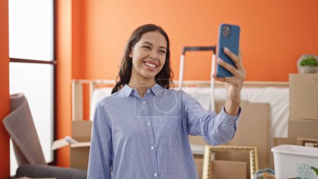 Photo for Young beautiful hispanic woman smiling confident make selfie with smartphone at new home - Royalty Free Image