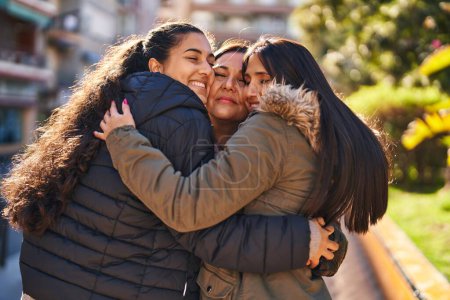 Téléchargez les photos : Trois femmes mère et filles se câlinent au parc - en image libre de droit