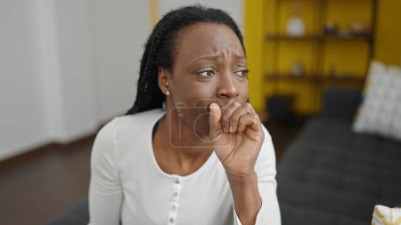 Foto de Mujer afroamericana estresada sentada en el sofá en casa - Imagen libre de derechos