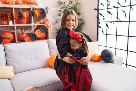 Photo for Adorable boy and girl wearing halloween costume hugging each other at home - Royalty Free Image