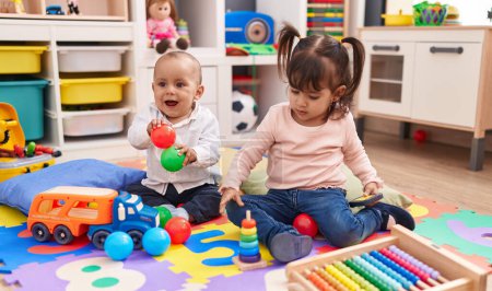 Photo for Adorable boy and girl playing with balls and hoops game at kindergarten - Royalty Free Image