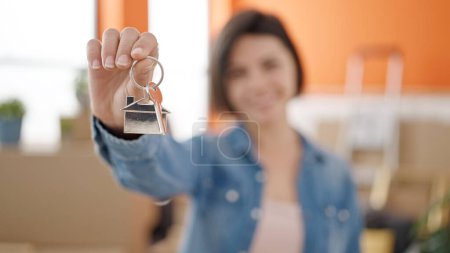 Téléchargez les photos : Jeune femme caucasienne souriante confiante tenant la clé à la nouvelle maison - en image libre de droit