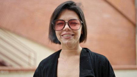 Téléchargez les photos : Jeune femme caucasienne souriant confiance debout à la rue - en image libre de droit